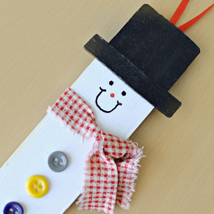 A snowman ornament made from a paint stirrer