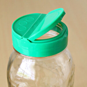 A lid from a can of parmesan cheese that fits on a canning jar