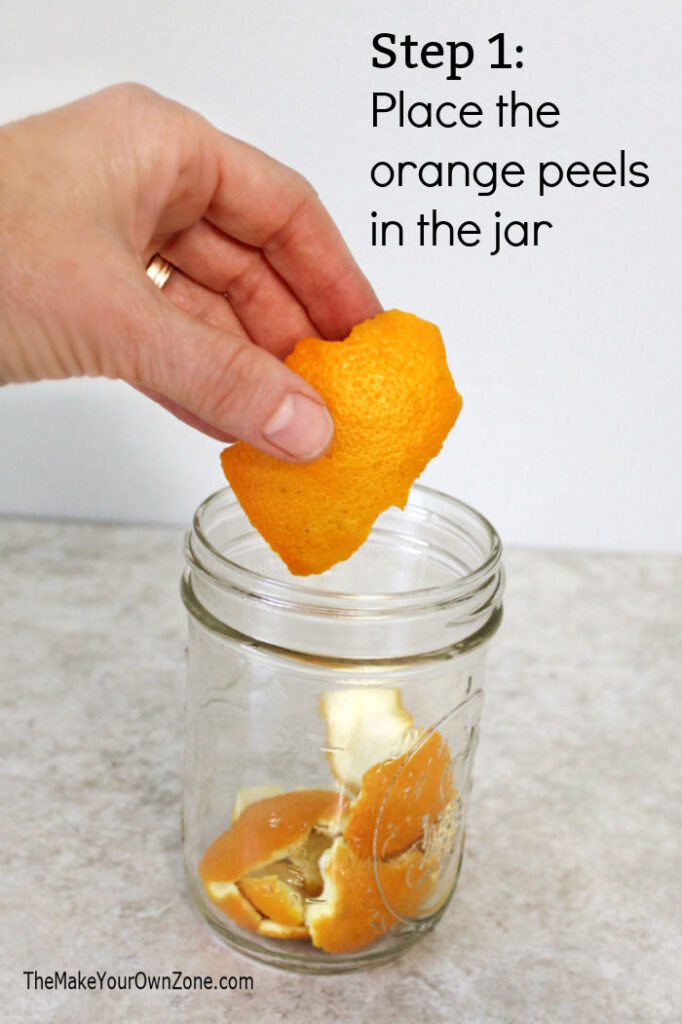 Putting orange peels in a pint jar to make scented cleaning vinegar