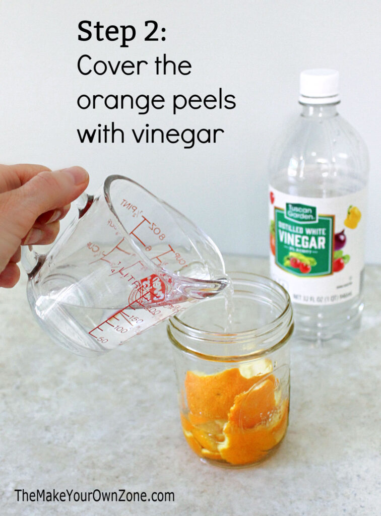 Pouring vinegar over orange peels to make scented vinegar