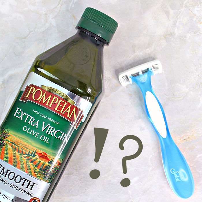 a bottle of olive oil for shaving legs with a razor