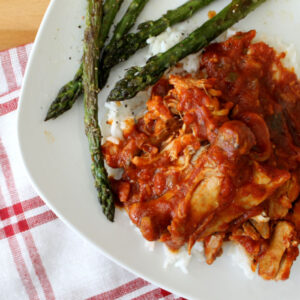 chicken cacciatore on a plate with asparagus