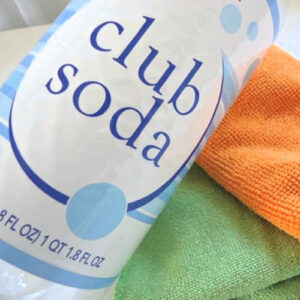 a bottle of club soda for cleaning glass