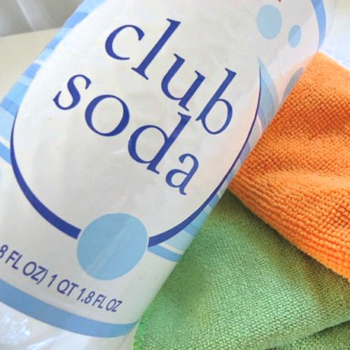 a bottle of club soda for cleaning glass