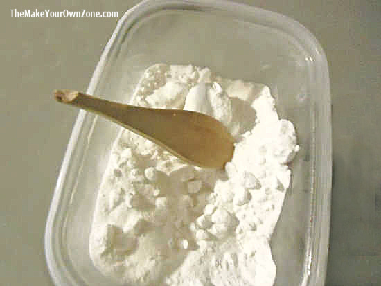 clumpy borax in a container with a broken wooden spoon