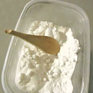 clumpy borax in a container with a broken wooden spoon