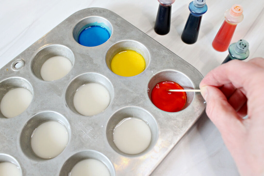 mixing food coloring into homemade watercolor paints
