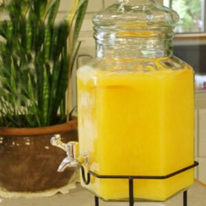 orange juice punch in a glass beverage dispenser