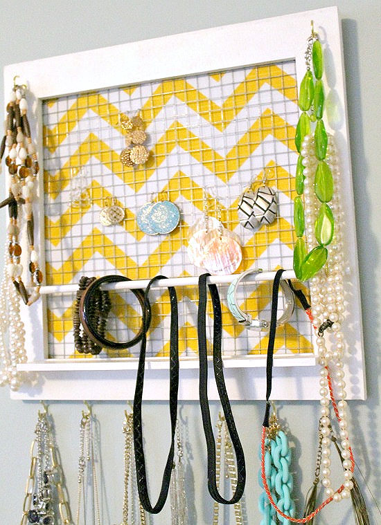 A homemade jewelry organizer made with a picture frame