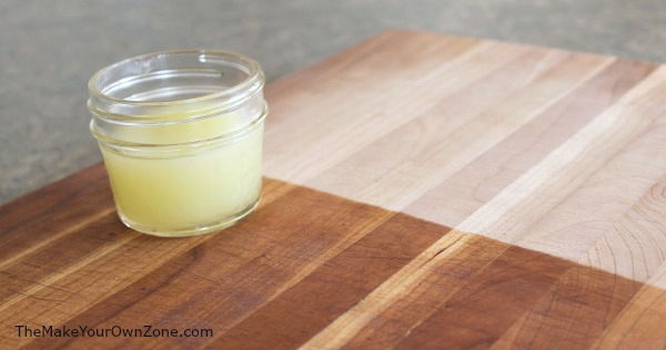 a cutting board with a jar of homemade wood conditioning cream