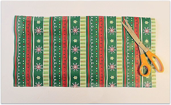 Cutting gift wrap to make a gift bag