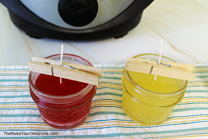 Using clothespins to hold a wick in place for DIY crockpot candles