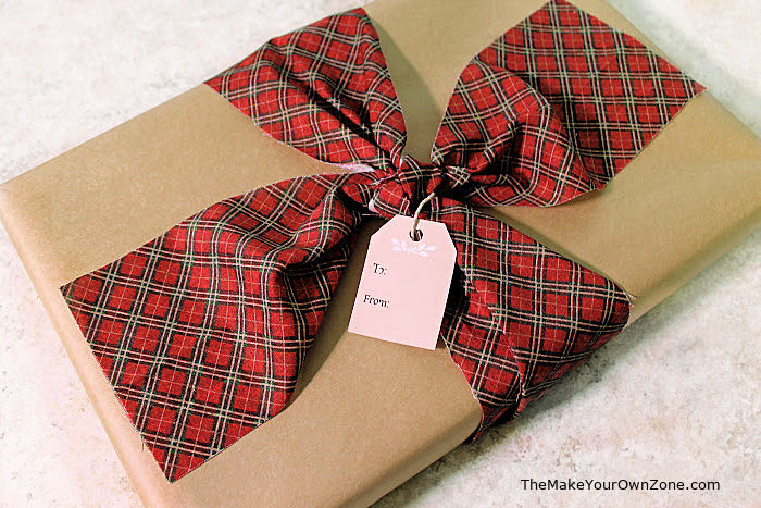 a gift box with brown kraft paper and red plaid fabric ribbon