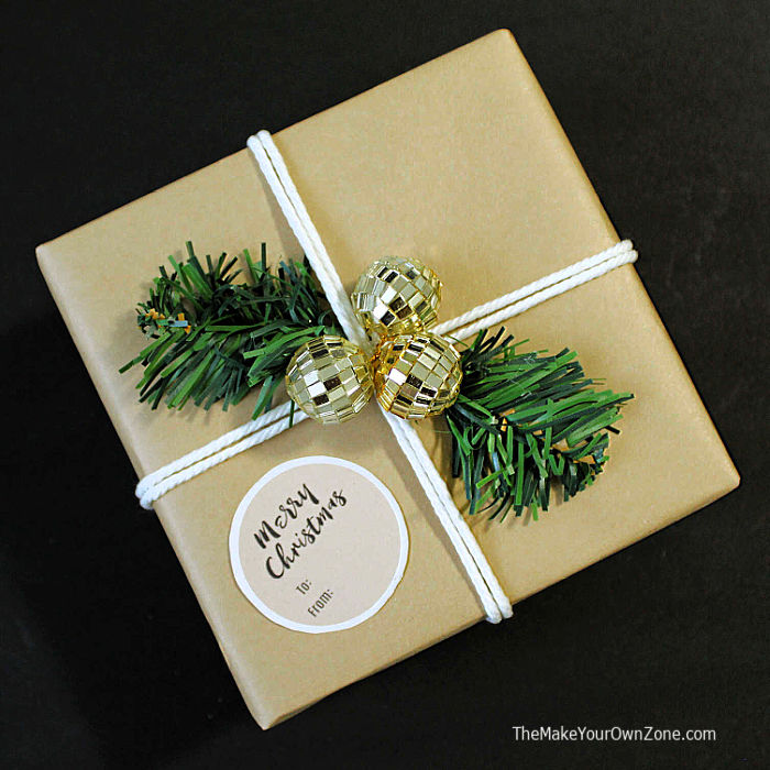 Gift box with brown paper tied with string and greens