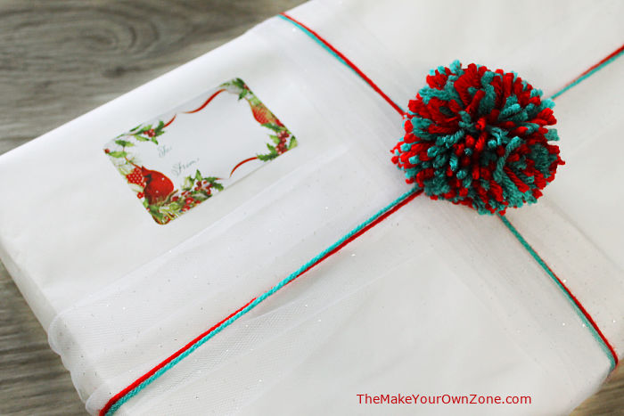 gift wrapped package decorated with red and green pom pom