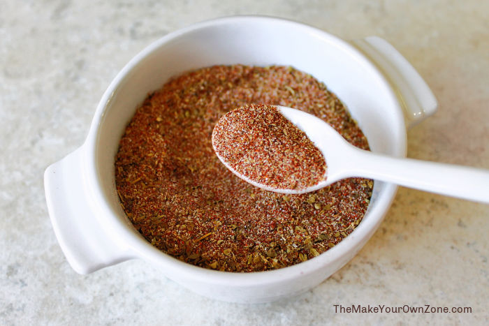 A small bowl of homemade spice blend with a spoon.