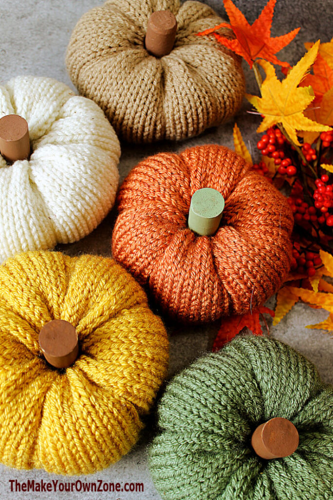 A group of mini knitted pumpkins in different colors.