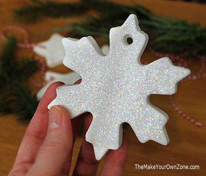 A homemade white clay snowflake ornament painted with glitter paint.