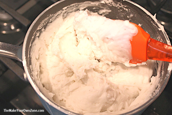 Stirring homemade baking soda white clay on the stove.