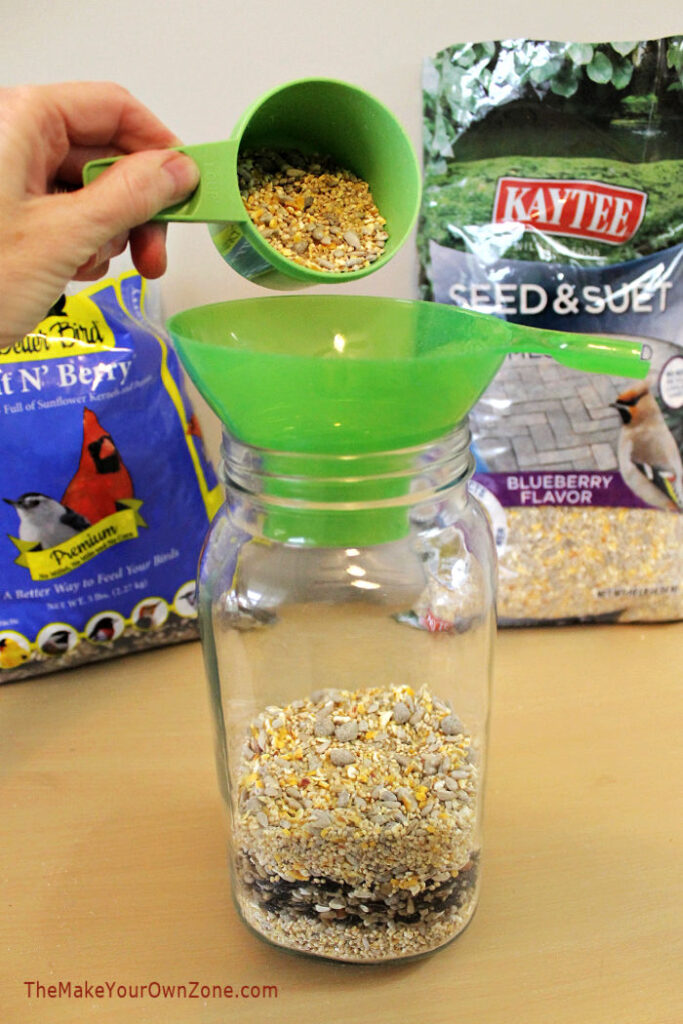 Filling a jar with bird seed to make a jar gift